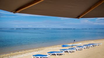 On the beach, white sand, sun-loungers, beach umbrellas