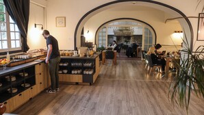 Um restaurante moderno com ilha central, piso de madeira e ambiente acolhedor.