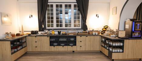 A kitchen with wooden cabinets, a coffee machine, and a breakfast bar.
