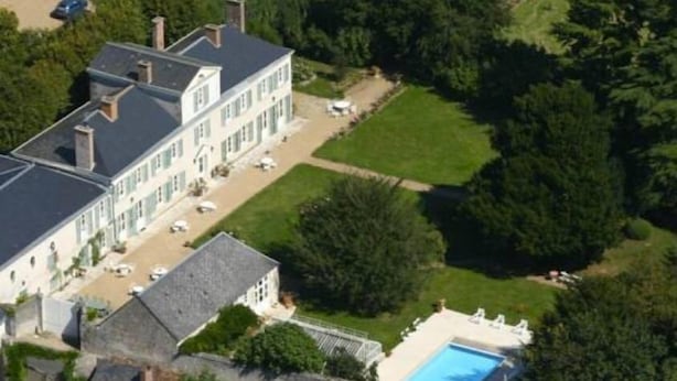 A large, multi-story building with a swimming pool, surrounded by lush greenery and a well-maintained lawn. - Château de la Rue (Suevres)