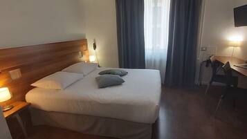 Une chambre d’hôtel avec un grand lit, un bureau et une chaise.