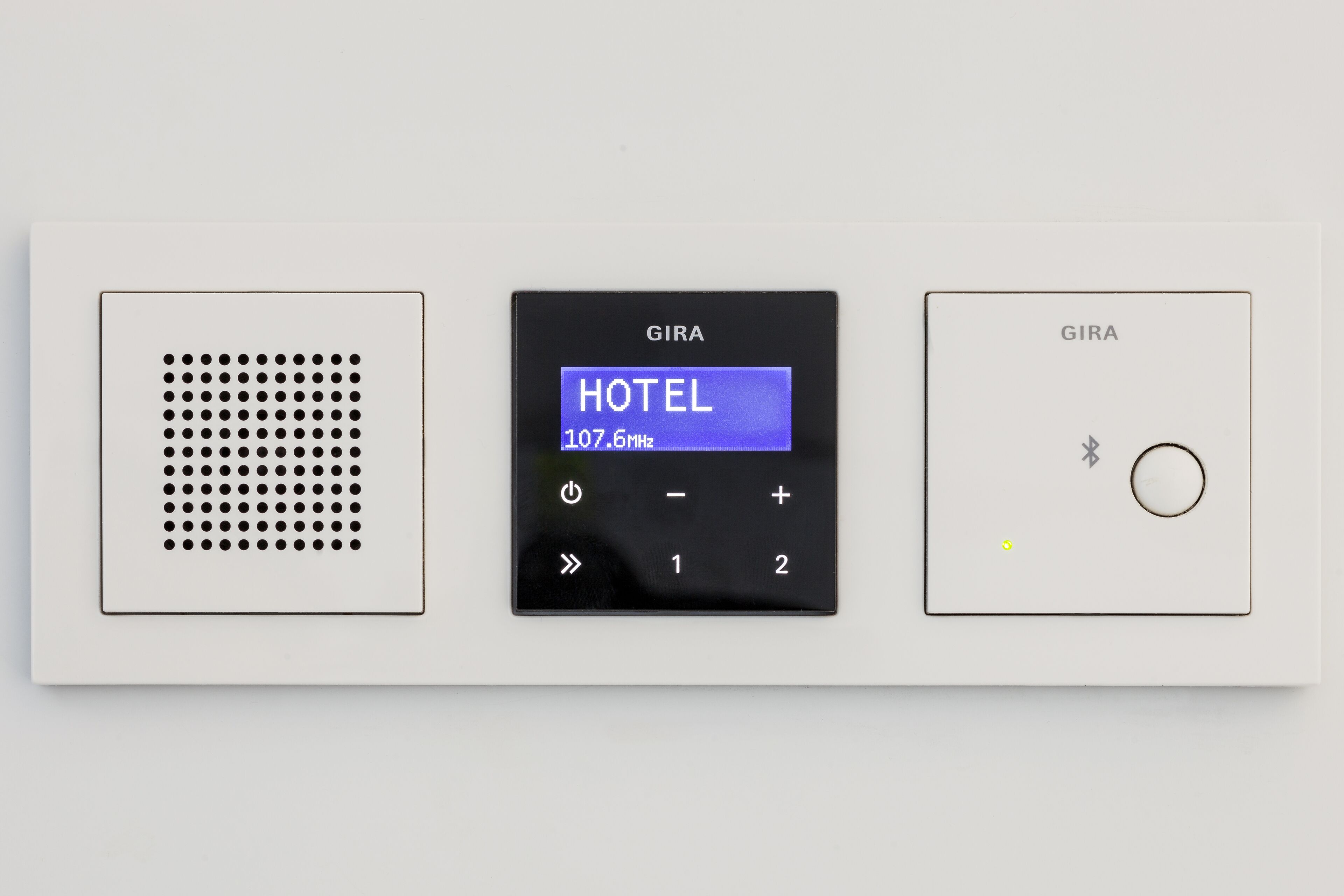 A control panel with a digital display labeled "HOTEL" and frequency "107.6MHz".