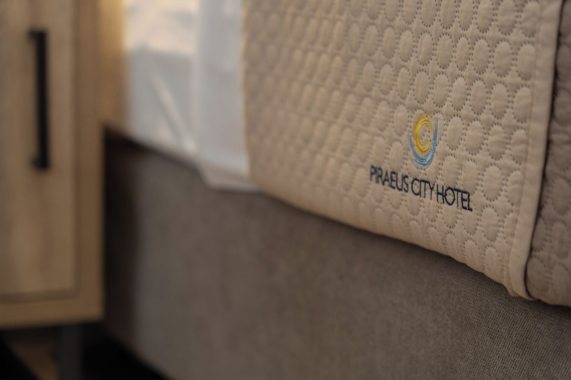 Primer plano de un tejido texturizado con el texto "PRAEUS CITY HOTEL" y un logotipo.