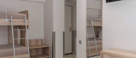A modern bedroom with bunk beds, a TV, and a mirror.