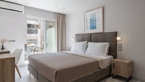 Une chambre moderne avec un grand lit, des tables de chevet, un bureau et un balcon avec vue.