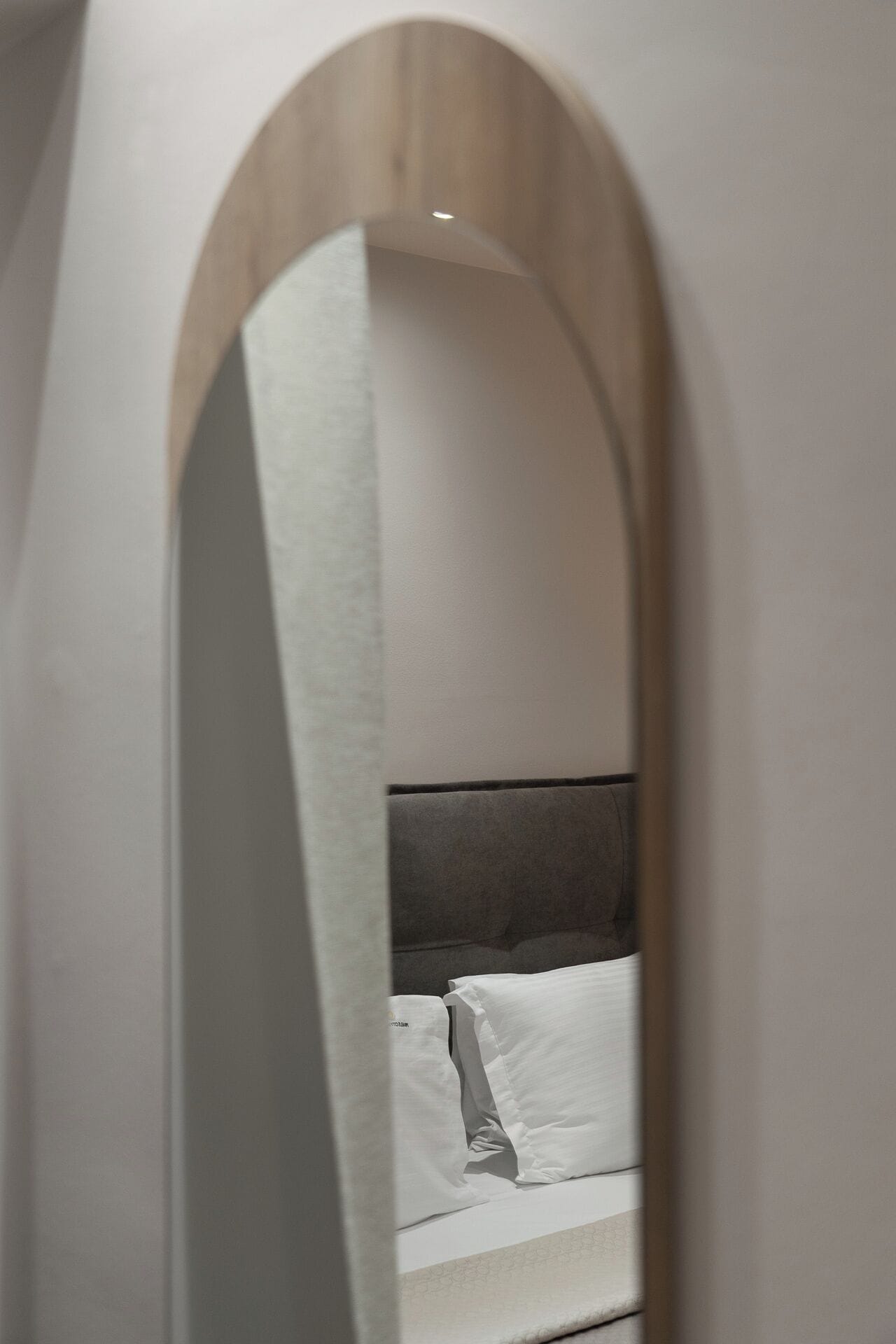 A bedroom with a bed, white bedding, and a wooden headboard.