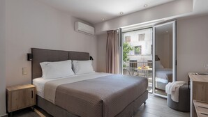 Une chambre d’hôtel moderne dotée d’un grand lit, d’une table de chevet, d’une armoire et d’un balcon offrant une vue sur la ville.