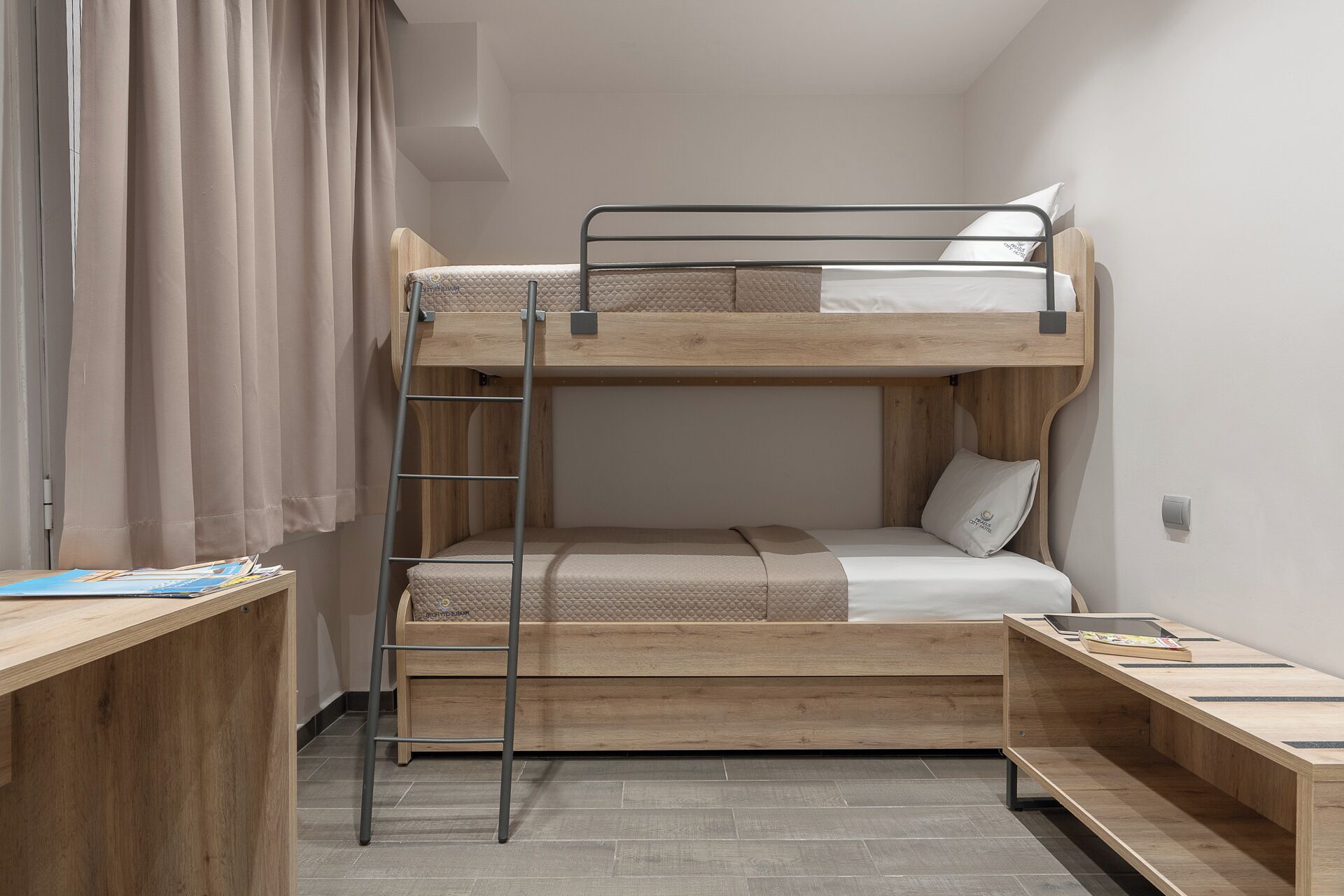 Une chambre avec un lit superposé, un bureau et une échelle.
