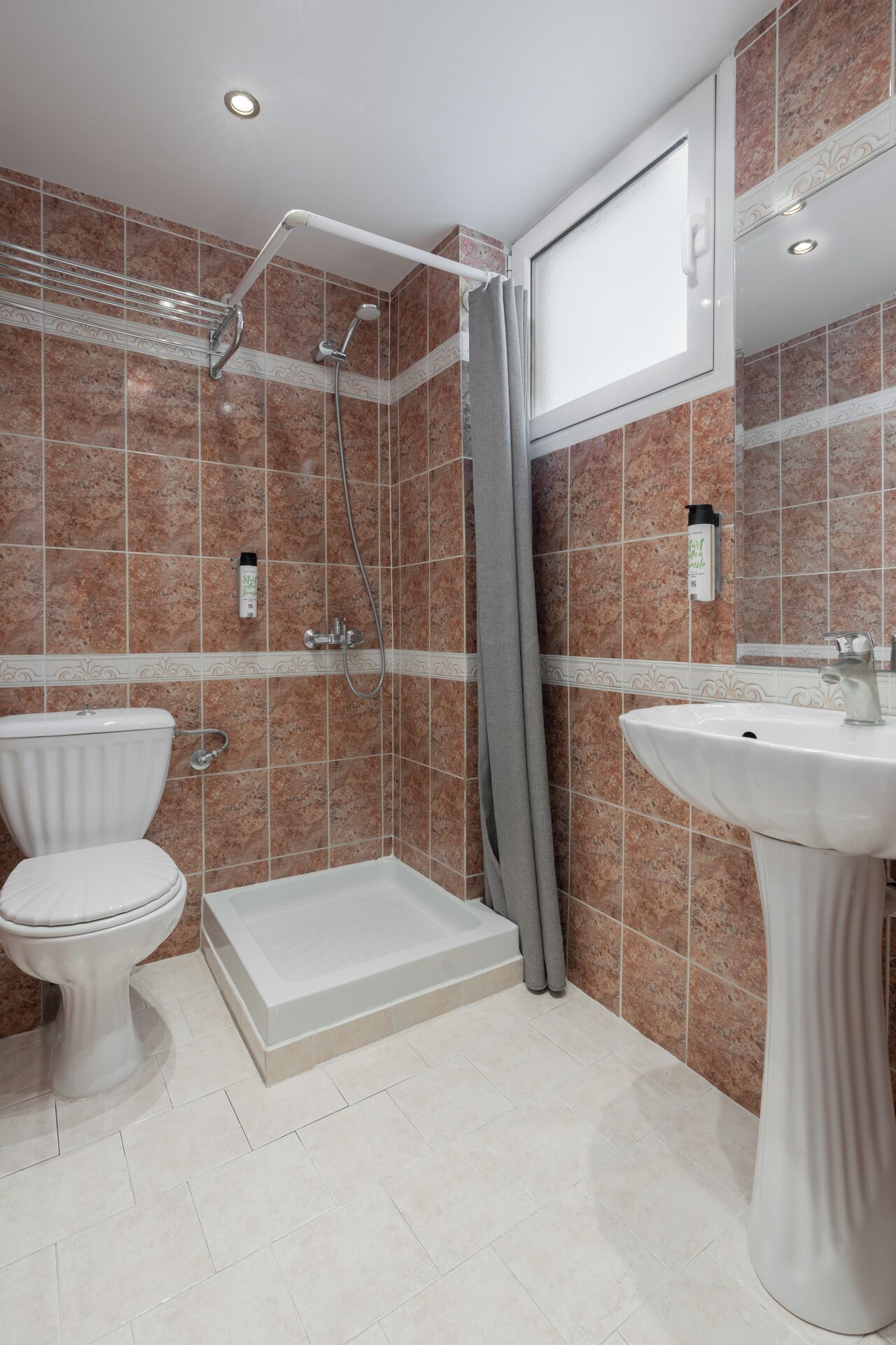 A bathroom with a shower, toilet, and sink.