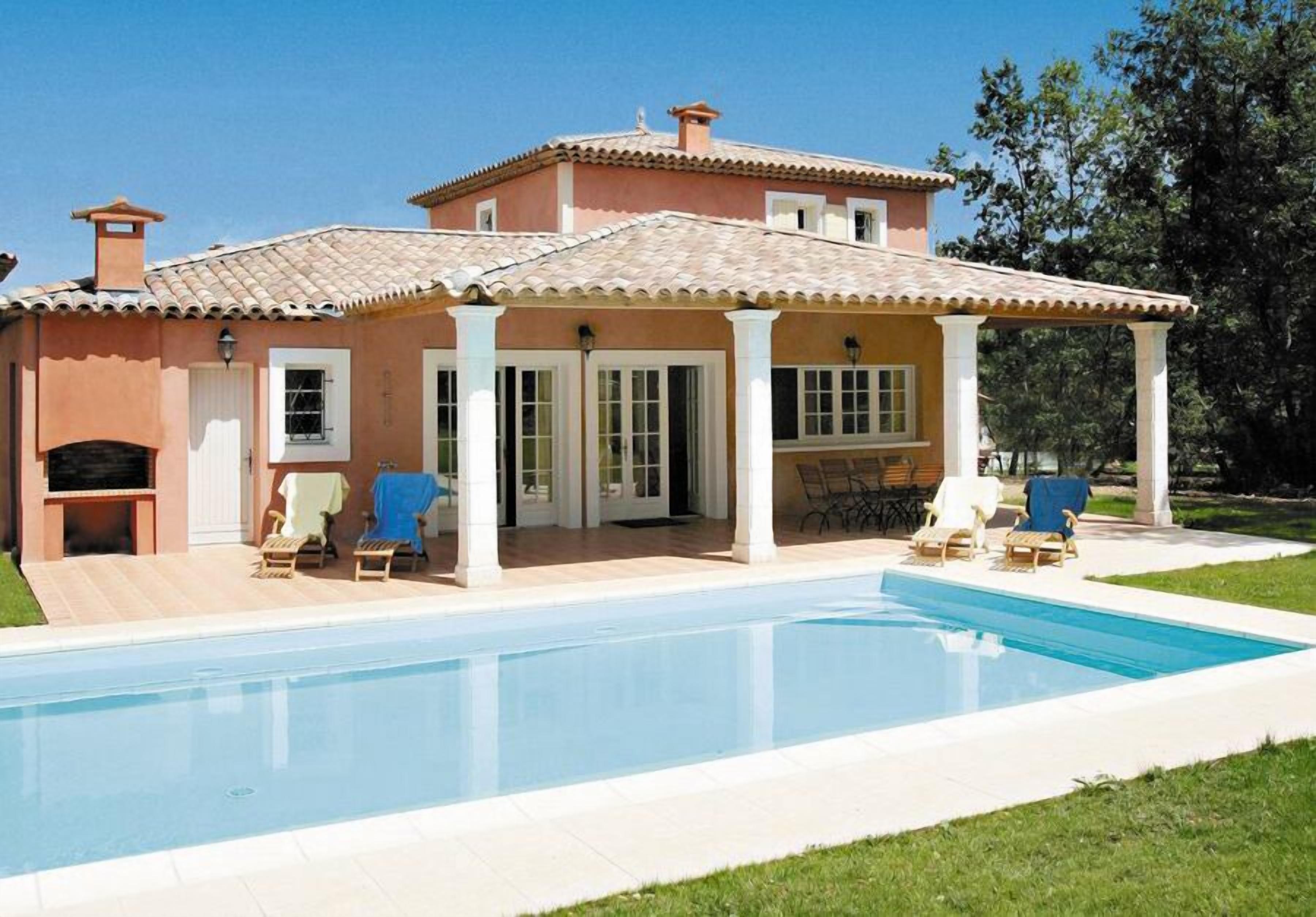 Une maison à deux étages dotée d’une piscine, d’un patio couvert et d’un espace salon extérieur.