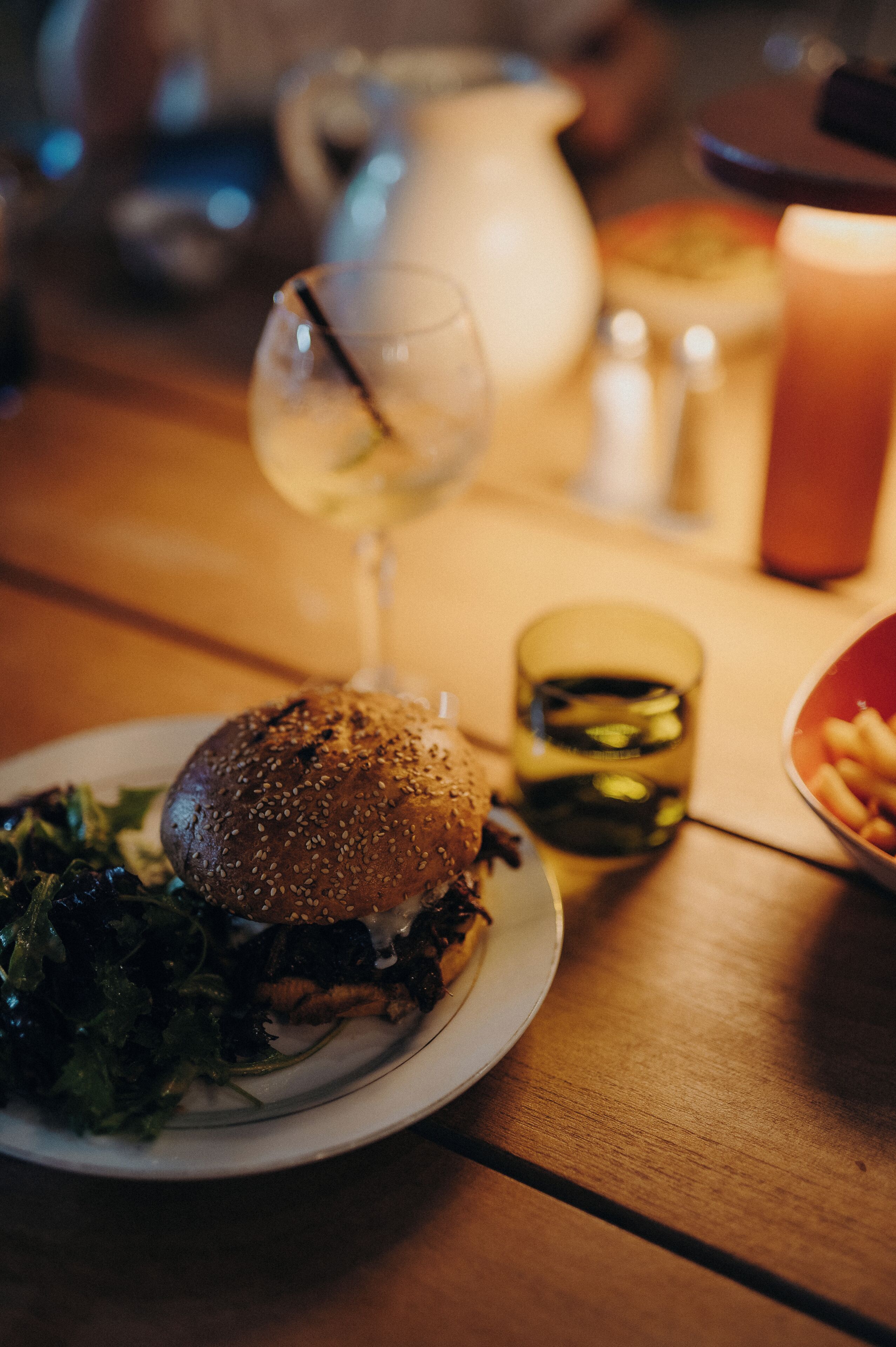 Un repas composé d’un sandwich, d’une salade et de boissons, servi sur une table en bois.