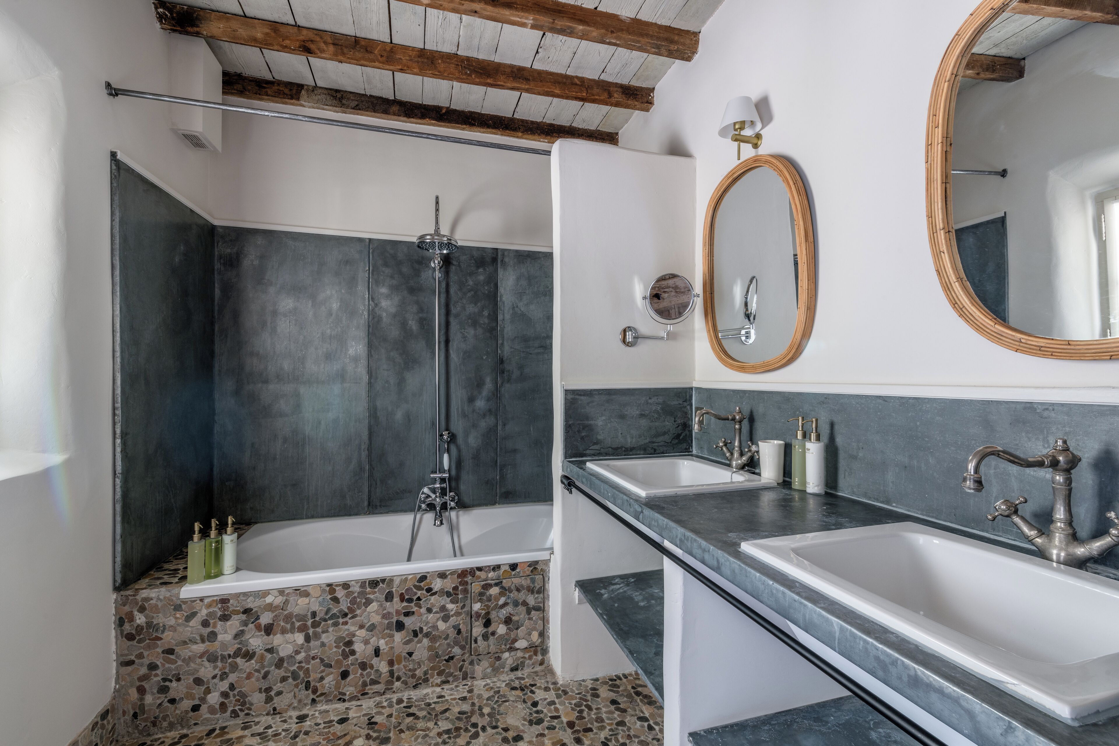 Een moderne badkamer met een groot bad, twee wastafels en een douche.
