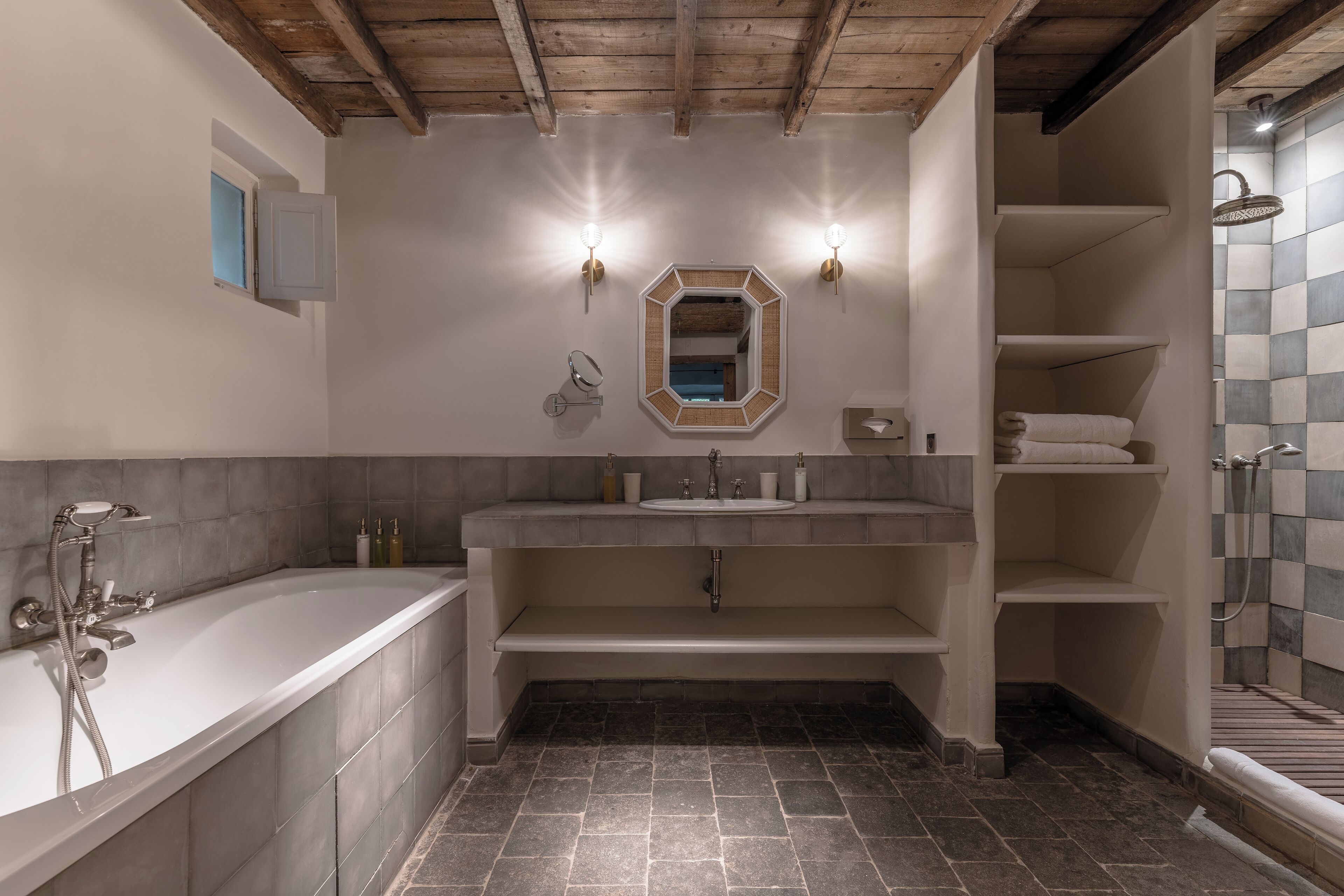 A modern bathroom with a freestanding bathtub, a vanity with a mirror, and a shower area.