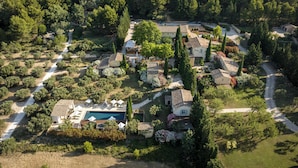 Vista aérea de un resort con varias villas, una piscina y un jardín bien cuidado.