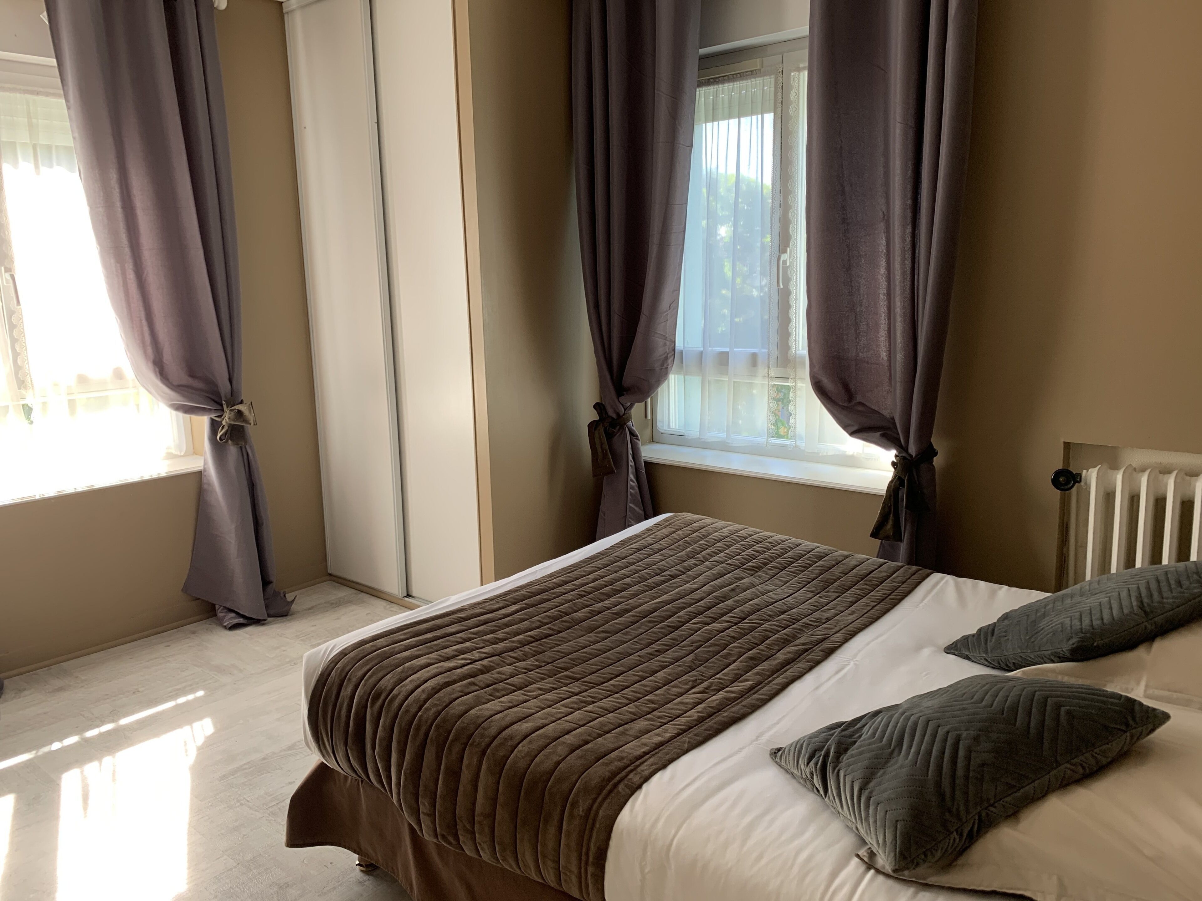 Un dormitorio con cama, cortinas y ventana.