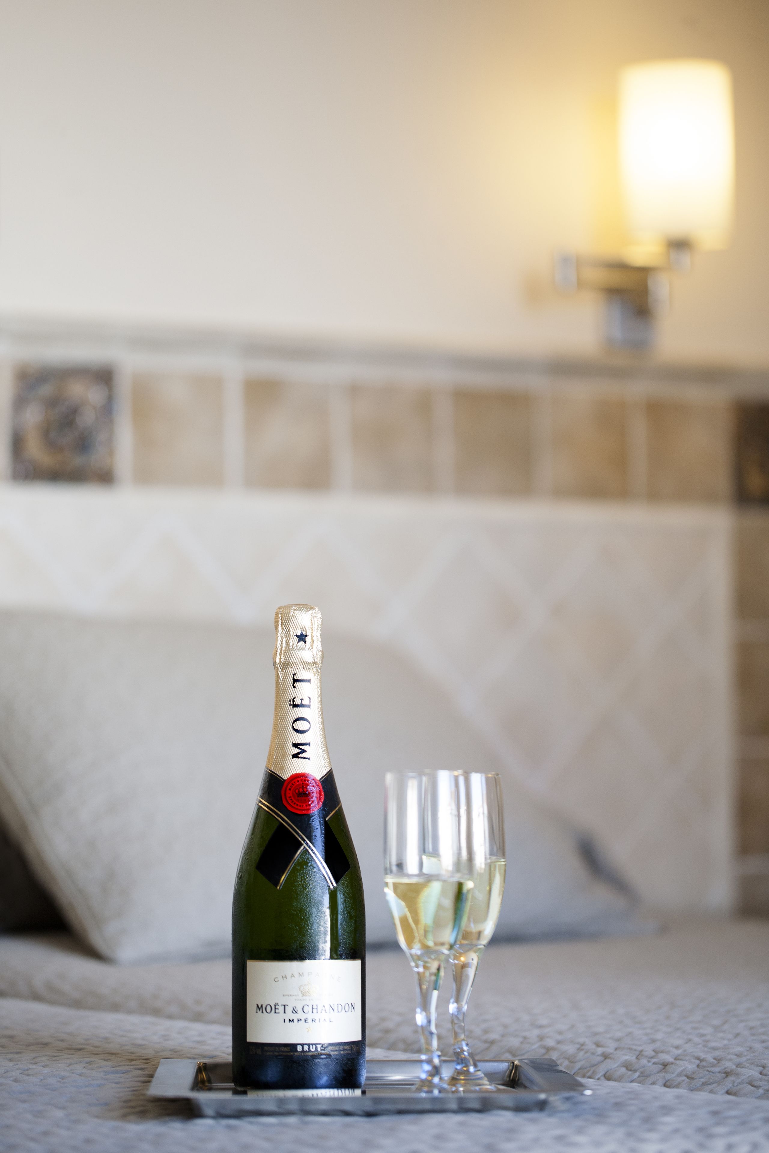 En flaska Moët & Chandon-champagne och ett glas på ett bricka i ett hotellrum.