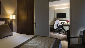 A hotel room with a bed, a desk, and a television.