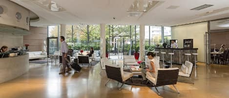 A spacious lobby with a reception desk, seating area, and a view of the outdoors.
