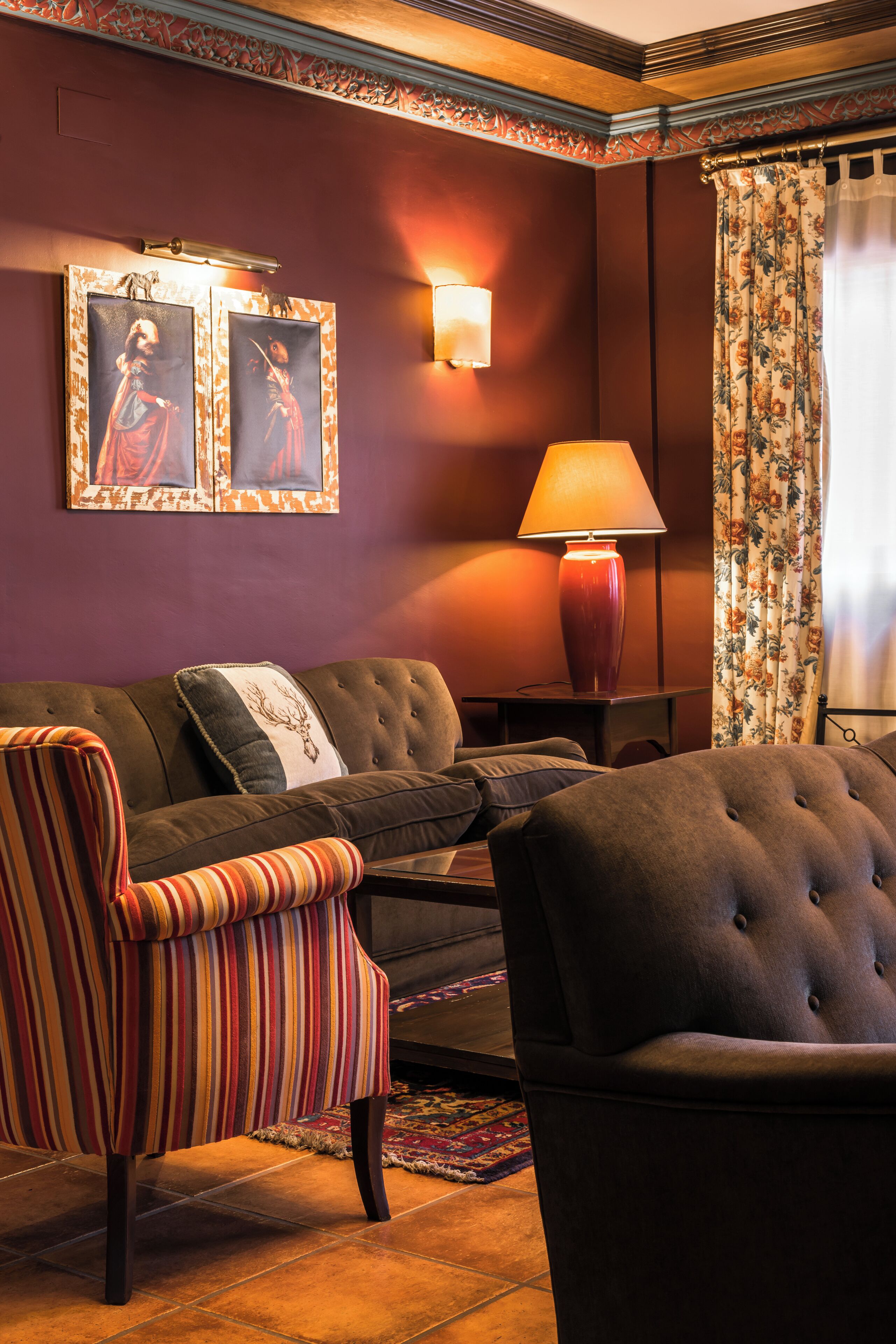 A living room with a sofa, striped armchair, and a lamp.