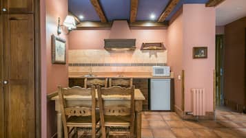 Una cocina con armarios de madera, salpicadero de azulejos y microondas integrado.