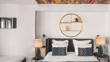 Una camera da letto moderna con un letto grande, due comodini con lampade, uno specchio rotondo e un soffitto con un motivo colorato.