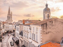 Una calle histórica con edificios, una torre destacada y una cúpula.