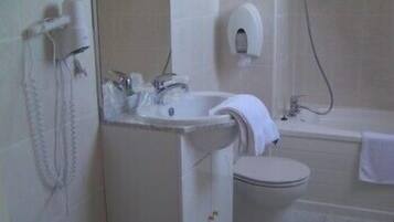 Un baño con lavamanos, inodoro y bañera.