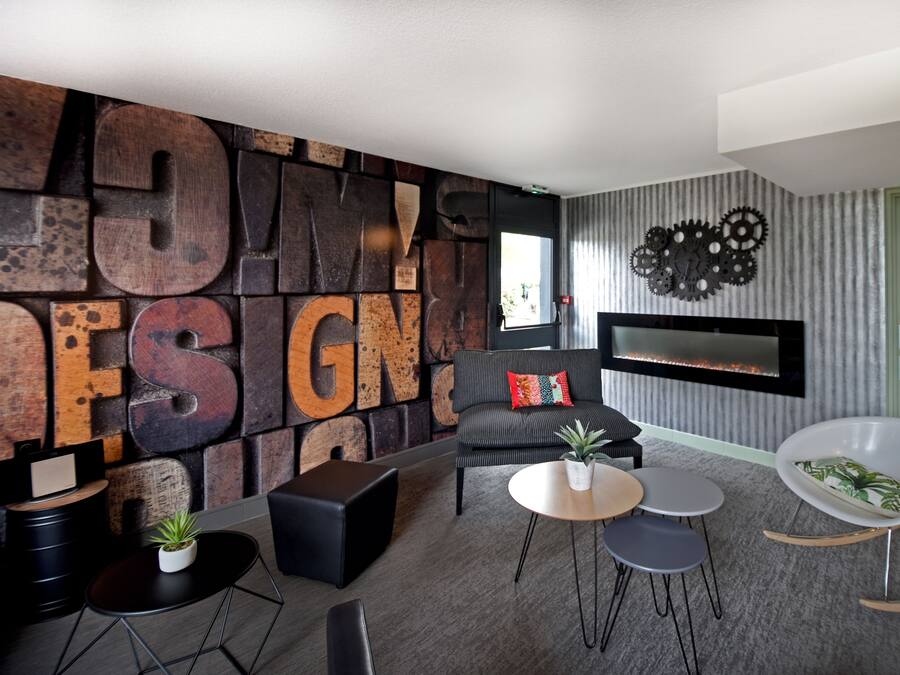 Una sala de estar moderna con una gran pared de letras de madera que deletrean "HOME DESIGN", una chimenea y muebles contemporáneos.