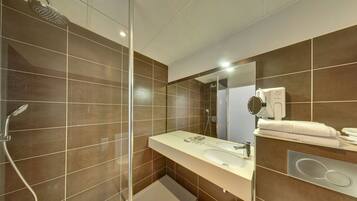 A modern bathroom with a shower, sink, and mirror.