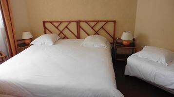A hotel room with a large bed, two bedside tables, and two lamps.