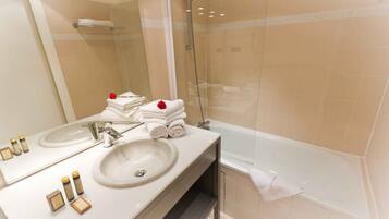 Une salle de bain moderne avec un grand miroir, deux lavabos, une baignoire et une douche.