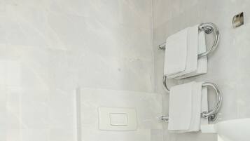 A modern bathroom with a bidet, toilet, and sink.