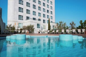 Una piscina cubierta, una piscina al aire libre, sombrillas, tumbonas