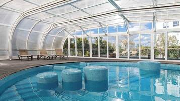 Piscine couverte, piscine extérieure, parasols de plage, chaises longues