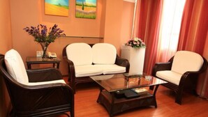 Una habitación con un conjunto de sofá, una mesa de centro y un jarrón con flores.