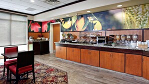 A hotel breakfast area with a counter, seating, and a large mural. - Fairfield Inn & Suites by Marriott Sudbury (Sudbury)