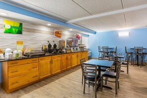 A breakfast bar with waffle makers, a coffee station, and a fruit display.