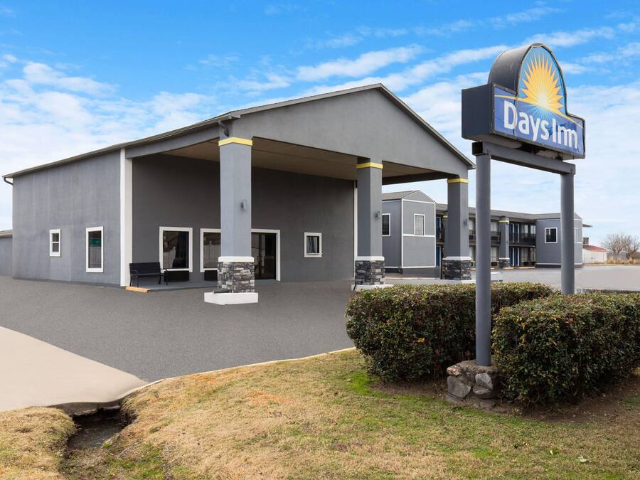 A Days Inn hotel with a covered parking area and a signboard.