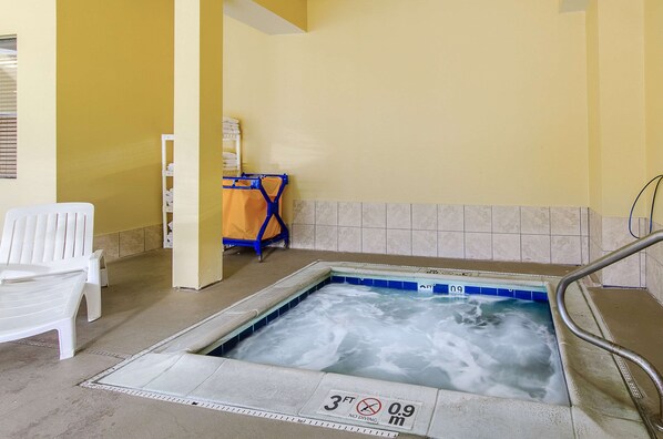 A hot tub with a 3 ft depth limit and a 0.9 m depth limit, surrounded by white chairs and a blue chair.