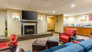 A hotel lobby with a fireplace, seating area, and a breakfast bar. - Comfort Suites Wytheville near Conference Center (Wytheville)