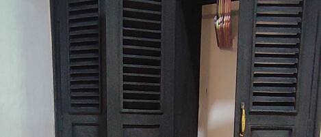 A closed wardrobe with a mirror and a door handle.