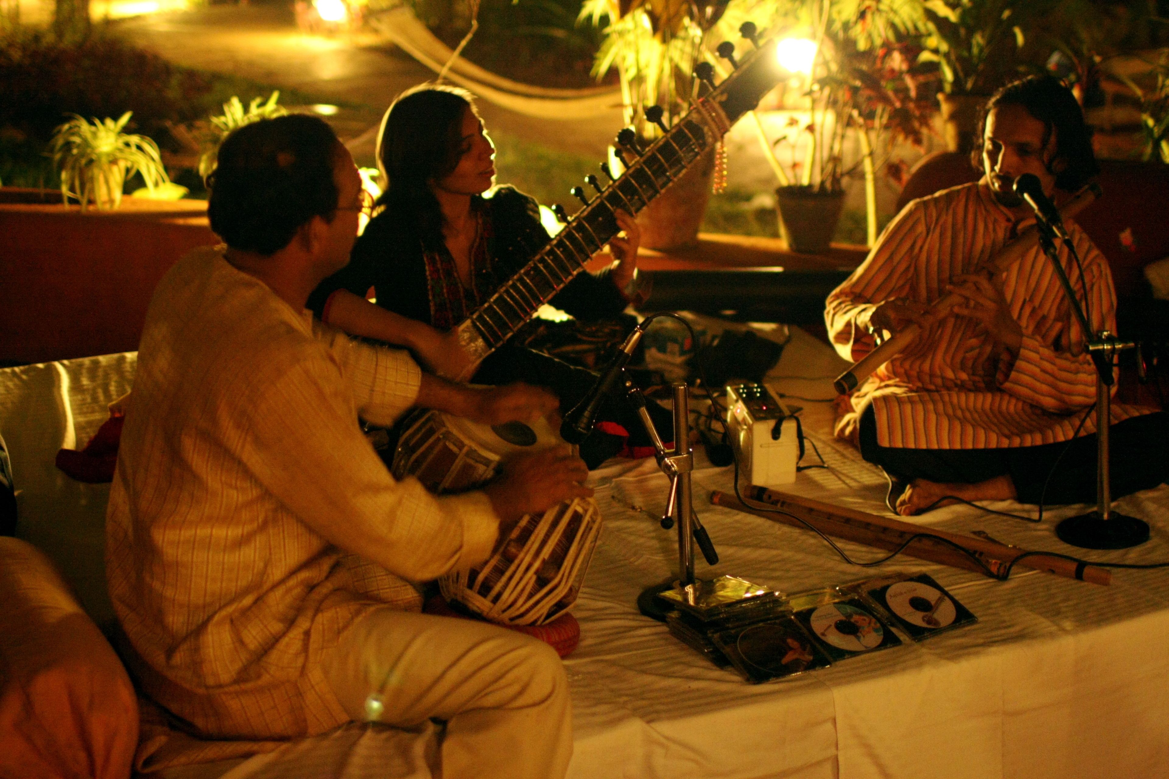 Un grupo de músicos actuando en un escenario con instrumentos musicales y un micrófono.