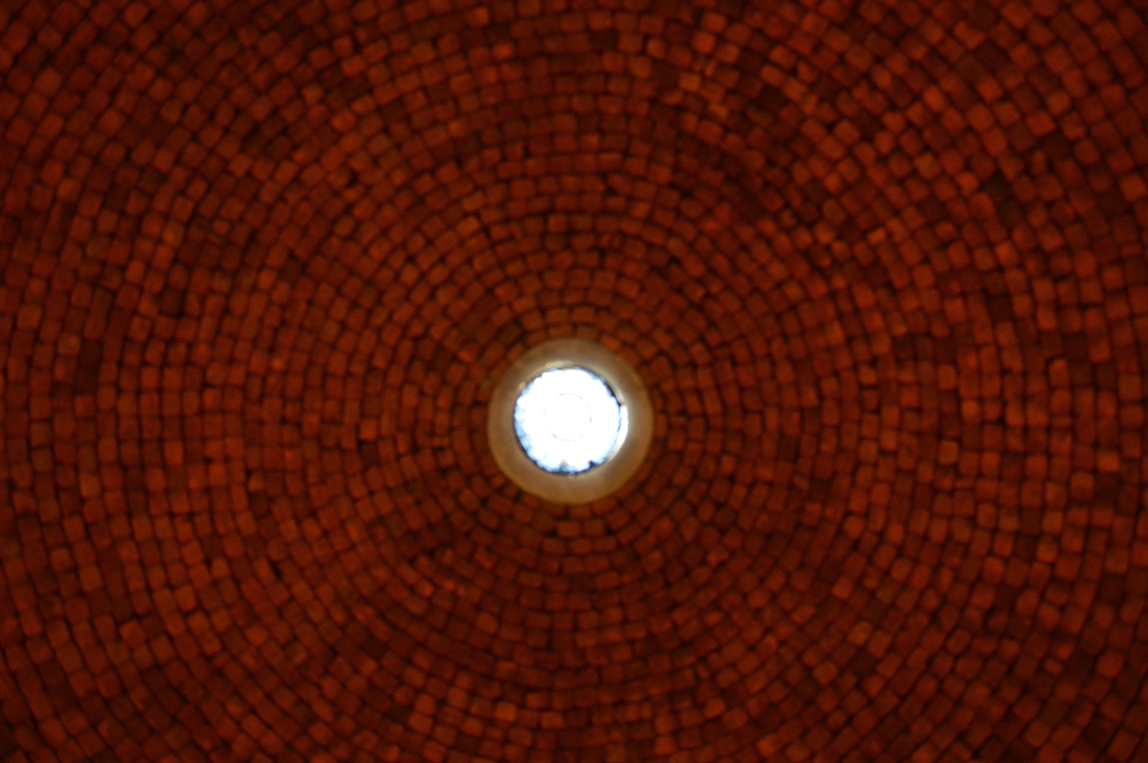 A circular brick ceiling with a central skylight.