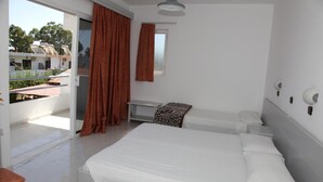 Un dormitorio con una cama grande, una mesita de noche, una ventana y vistas al balcón exterior.