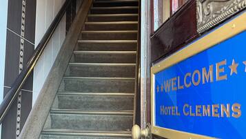 A staircase leading to a hotel entrance with a sign reading "WELCOME HOTEL CLEMENS".