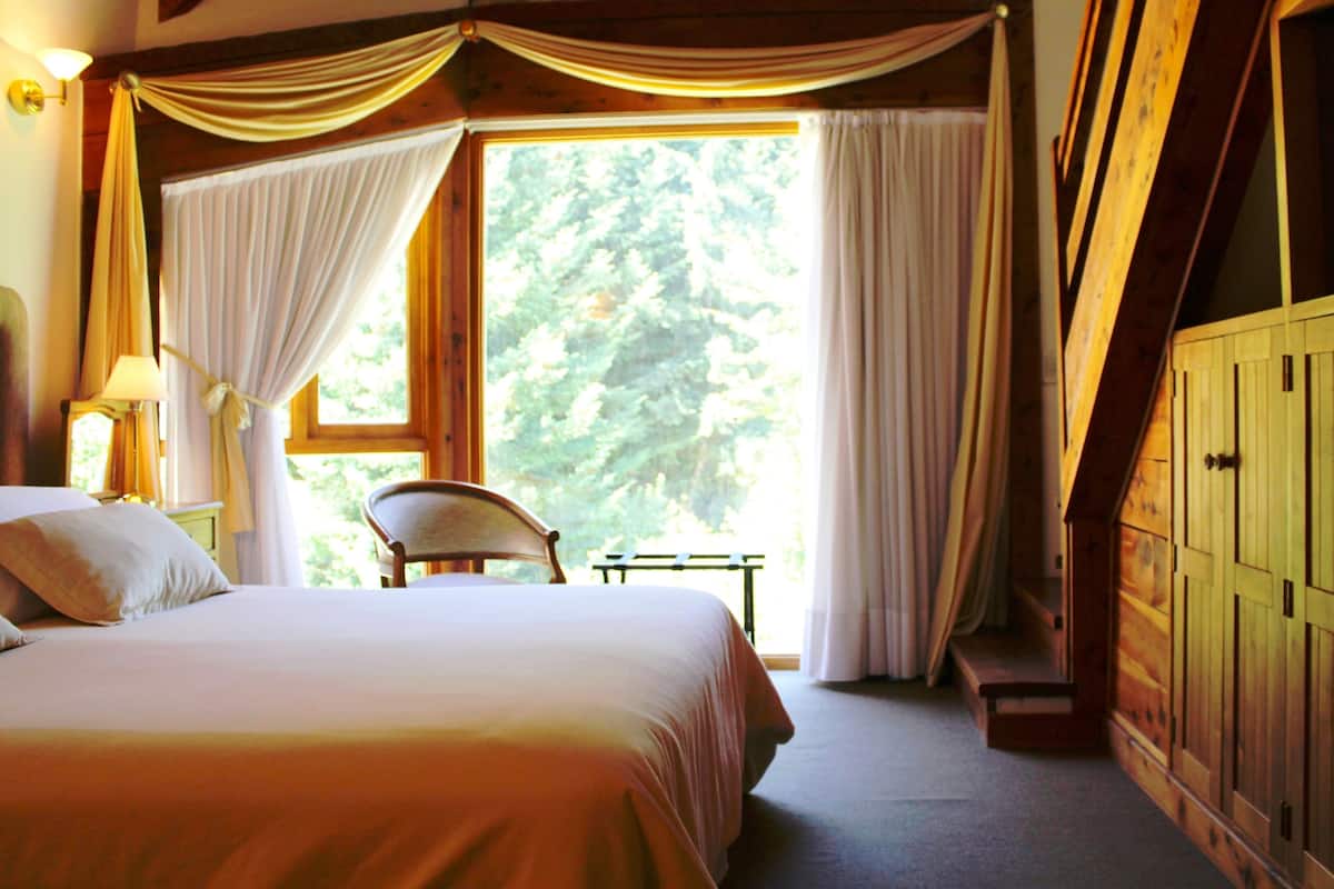 Une chambre à coucher avec un grand lit, une chaise et une armoire en bois.