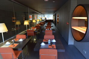 A modern dining area with tables and chairs, equipped with table settings and ambient lighting. - Soho Hotel (Barcelona)