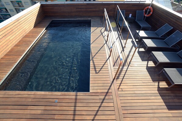 Una piscina al aire libre de temporada, sillones reclinables de piscina