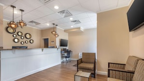 A spacious lobby with a reception desk, a seating area with a sofa and armchairs, and a television mounted on the wall. - Best Western Ocean City Hotel & Suites (Ocean City)