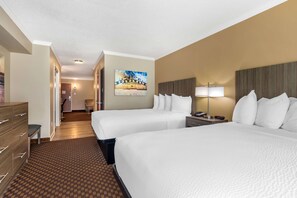 A hotel room with two beds, a desk, a chair, a lamp, and a painting on the wall. - Best Western Ocean City Hotel & Suites (Ocean City)